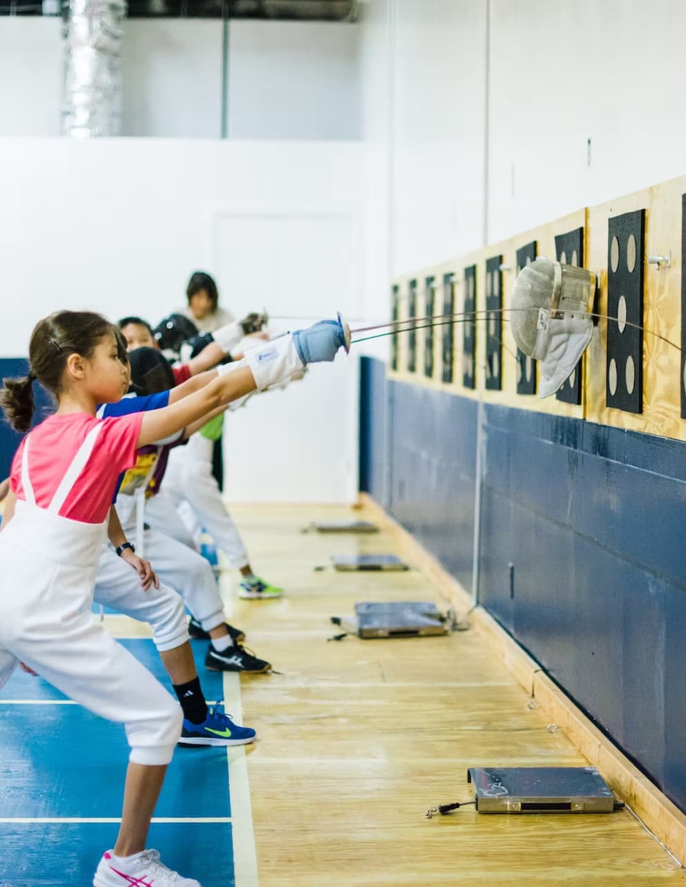 Young Birmingham Fencing Academy student practicing in a pink shirt